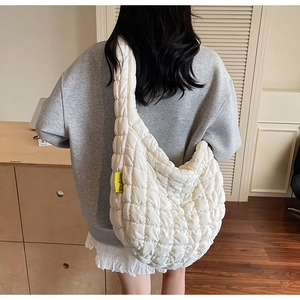 Detail shot of the white quilted cloud bag featuring a yellow Fashion logo tag on the side
