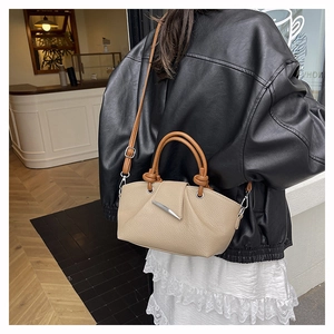 Close-up of bicolor lychee texture leather bag with silver horn buckle and top handle
