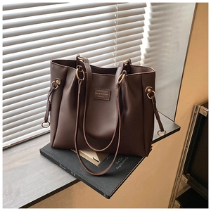Vista dettagliata della borsa tote in pelle marrone scuro con coulisse e anelli metallici