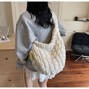 Close-up of white quilted bubble shoulder bag with a yellow Fashion label on the side