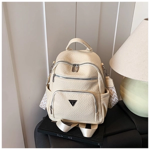 Detail of cream white faux leather backpack with metallic triangle logo and woven strap