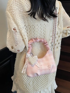 Pink checkered dumpling bag with ribbon lace and pearl heart charm on a chain strap