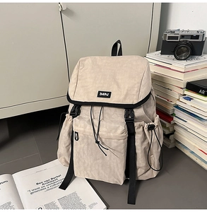 Detailed view of beige outdoor backpack featuring DAPJ logo and buckle drawstring closure