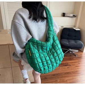 Detail of quilted bright green cloud bag showing the soft puffy texture and size on model