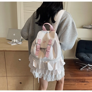 Detail of ruffled hem and pink polka dot pattern on a stylish women's backpack