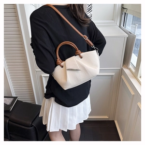 Detail of lychee textured tote bag with pleated design and brown shoulder straps