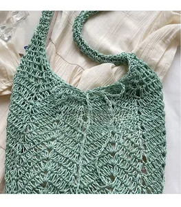 Close-up of mint green hollow crochet texture on a large capacity straw shoulder bag