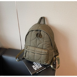 Close-up of olive green quilted nylon backpack with premium diamond stitching texture