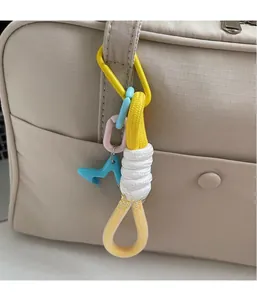 Dettaglio di un portachiavi colorato intrecciato con stella blu su borsa di tela beige