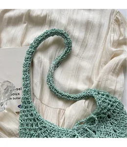 Detail showing the light green hand-woven crochet mesh texture and long shoulder strap