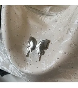 Gros plan sur l'ornement papillon en métal liquide sur un sac jacquard à strass