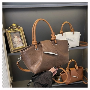 Detailed display of lychee pattern leather tote bags with elegant knot handles and metal decor
