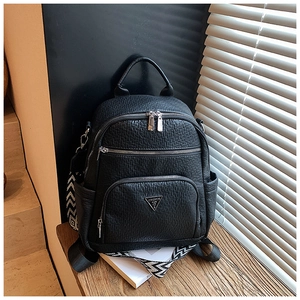 Detail of black faux leather backpack with textured finish and silver triangular logo