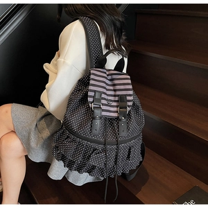 Close-up of black polka dot backpack featuring three-layer ruffle trim and buckle detail