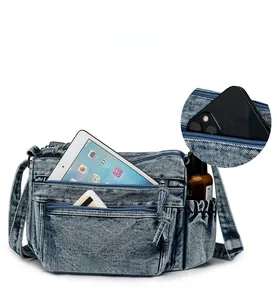 Détail du sac bandoulière en denim avec compartiments zippés et rangement téléphone