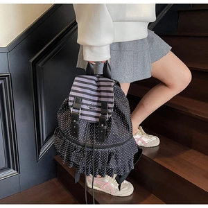 Polka dot backpack detail showing layered ruffle trim and striped flap with embroidery