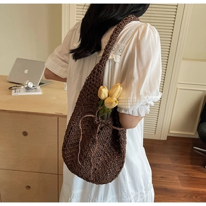 Detailed texture of dark brown woven cotton rope bag with hollow knit design and drawstring