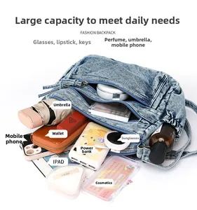 Sac fourre-tout en jean spacieux avec plusieurs compartiments montrant les accessoires