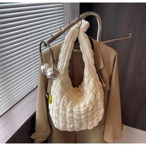 Detail of white quilted puffy bag with yellow fashion tag hanging on a stand
