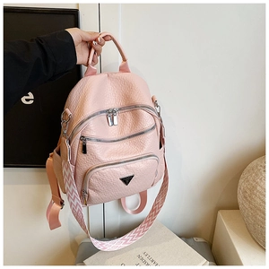 Close-up of pink lychee grain PU leather backpack with silver zippers and geometric strap