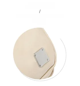 Close-up of square silver metal hardware on a beige crossbody bag with textured leather