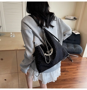 Détail du sac bandoulière noir en croissant avec breloques perles et chaînes argent