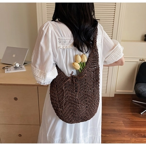 Brown hollow knit hobo tote bag shown worn on shoulder in a warm lifestyle setting