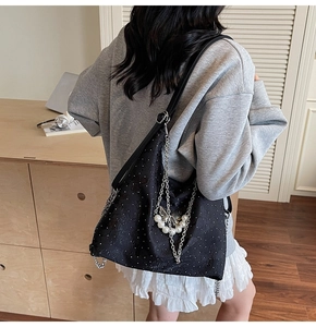 Détail du sac cabas noir en tissu jacquard avec papillon en perle et chaînes fines