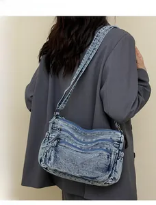 Vue détaillée du sac cabas en jean délavé avec poches multiples porté par le mannequin