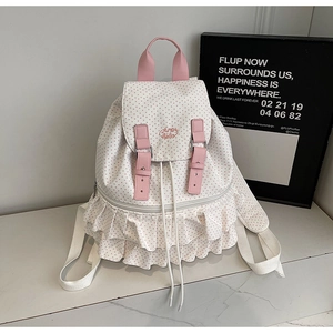 Detail of pink polka dot backpack with ruffled edges and metal buckle strap closure