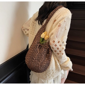 Close-up of brown hollow-out knitted tote bag with leaf pattern and drawstring detail