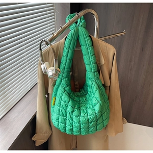 Close-up of grass green quilted cloud bag with yellow Fashion label and casual styling