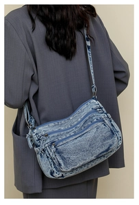 Vue arrière d'un mannequin portant un grand sac bandoulière en jean délavé multi-poches