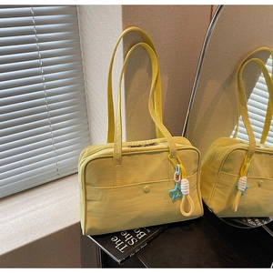Dettaglio della borsa tote in tela crema con cuciture a contrasto e ciondolo a stella