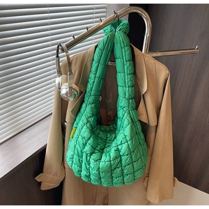Close-up of green quilted bubble bag with Fashion tag hung on a stylish trench coat