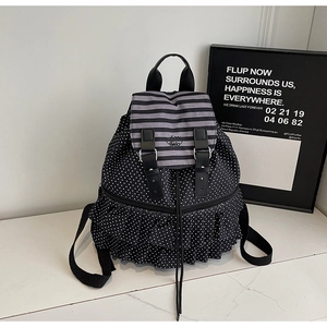 Detailed view of polka dot backpack featuring double ruffle layers and drawstring closure