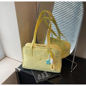 Dettaglio di una borsa tote in nylon verde lime con ciondolo a stella blu e tasca