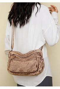 Sac bandoulière vintage en toile marron délavée avec plusieurs poches zippées porté
