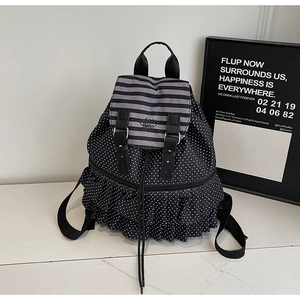 Detailed view of polka dot backpack with ruffled trim and striped Hello logo flap