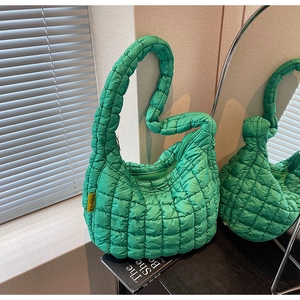 Detail of green quilted puffer bag with soft cloud texture and yellow fashion tag