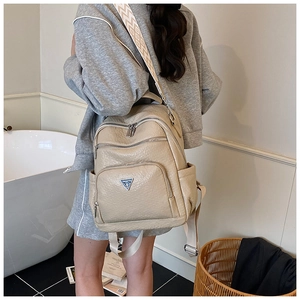 Detailed back view of beige lychee grain backpack with textured geometric wide strap
