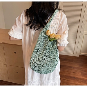 Close-up of light green crochet woven tote bag with hollow grid and yellow tulips detail