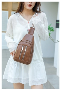 Brown vintage leather crossbody chest bag with detailed geometric woven strap and zip pockets
