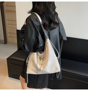 Détail d'un sac cabas blanc à gaufrage papillon avec chaîne argentée et perles