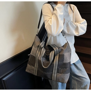 Detail of grey patchwork tote bag showing contrast stitching and metal hook