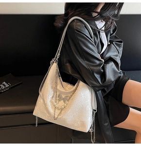 Détail du sac hobo en dentelle blanche avec chaîne en perles et décor papillon