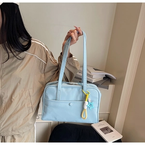 Dettaglio della borsa tote in tela azzurra con ciondolo a stella e corda intrecciata