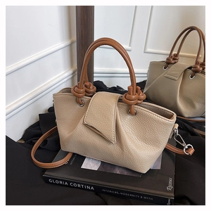 Close-up of lychee grain leather texture and triangular flap with metal edging detail