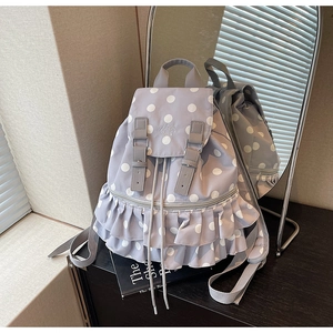 Detail of lavender polka dot backpack with ruffles, flip-top buckles and drawstring closure