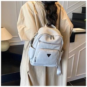Detail of light gray pebbled leather backpack with triangular logo and front pocket
